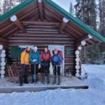 Two couples stand in front of Jacques Lake Hut.