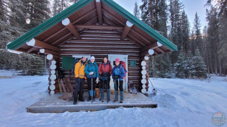 Two couples stand in front of Jacques Lake Hut.