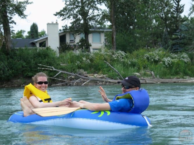 Man and lady in a small raft on the Bow River. 