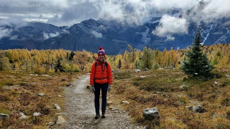 Person with golden larches behind them.