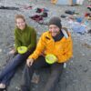 Two people sitting on the sand with a Sea to Summit X-Bowl in their hand.