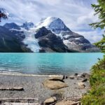 Turquoise waters of Mt. Robson's Berg Lake beside the trail, surrounded by rugged mountains and glaciers.