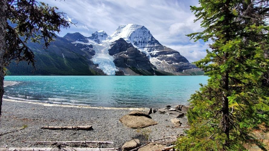 Turquoise waters of Mt. Robson's Berg Lake beside the trail, surrounded by rugged mountains and glaciers.
