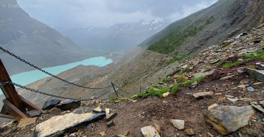 Hiker using a safety chain to descend a rocky section on the Snowbird Pass trail.