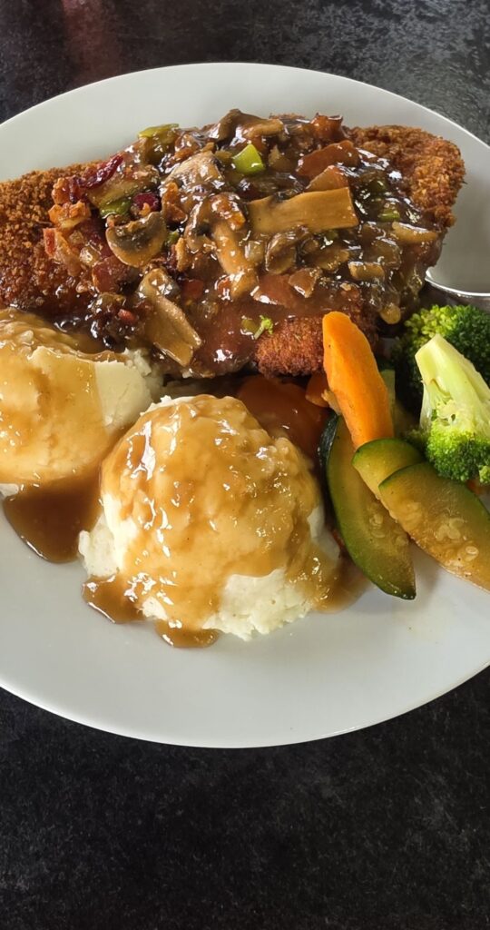 A delicious plate of mushroom schnitzel with a side of veggies. 