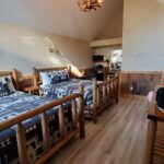 Inside a guest room at Jasper Gates Resort in the Canadian Rockies showing a bed and typical hotel room layout.