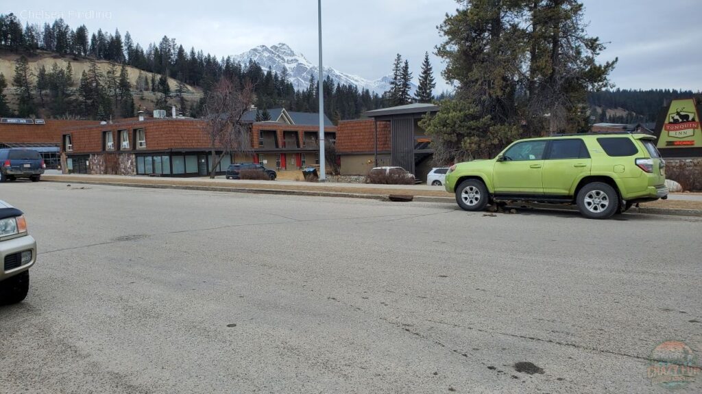 Looking at Tonquin Inn with mountains and buildings in the background.