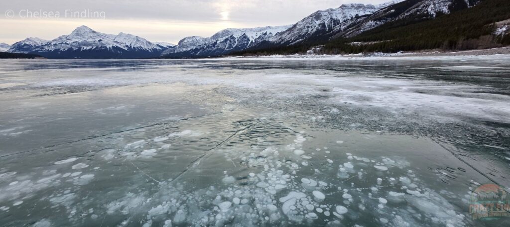 Methane ice bubbles trapped beneath the clear surface, forming layered pancakes.