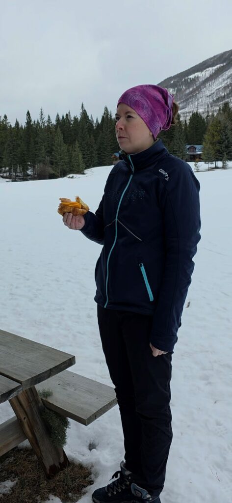 Woman enjoying a sandwich outdoors.