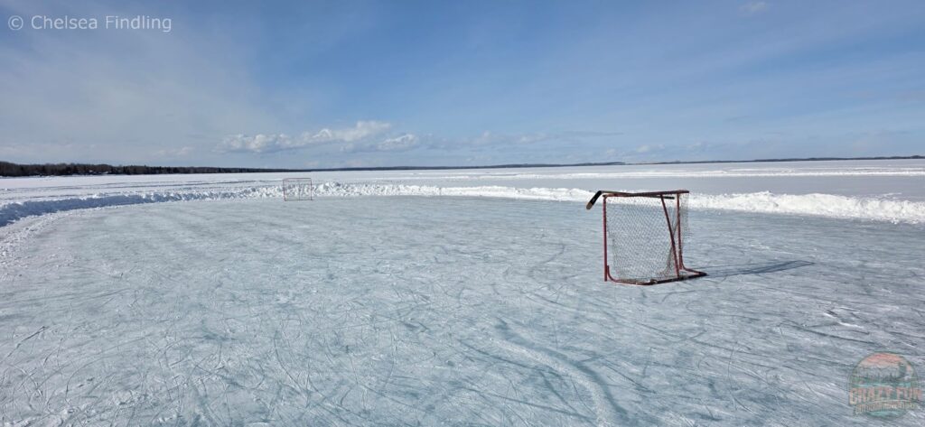 Hockey nets set up on the frozen ice at Pigeon Lake, creating a casual outdoor rink for skating and pickup games.
