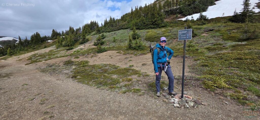 Hiker beside the Little Shovel Pass sign.
